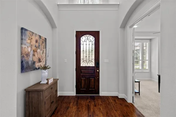 a view of a hallway to rooms and wooden floor