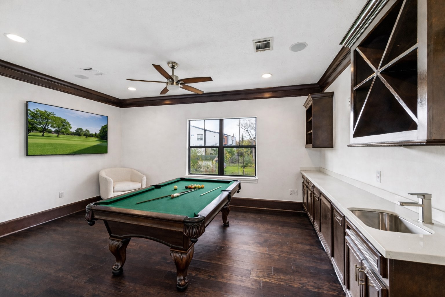 3942 Charleston Street Houston, TX 77021 - Photo 18 of 34 A dedicated game room with a built-in wet bar creates a natural spot for downtime and hosting. Dark wood floors and custom cabinetry keep the space polished and cohesive. *virtually staged*