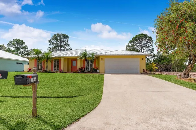 a front view of a house with a garden and yard