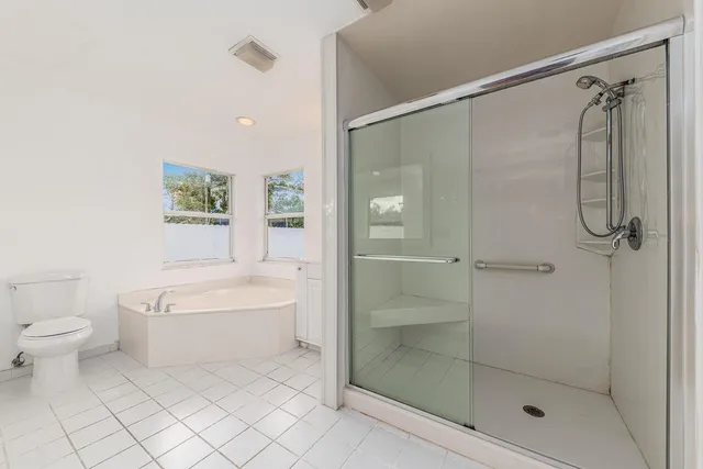 a bathroom with a bathtub shower sink vanity and toilet