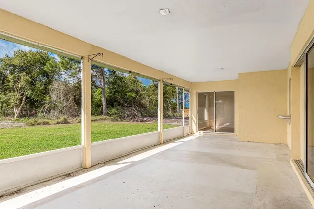 a view of an empty room with wooden floor and a floor to ceiling window