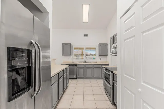 a large kitchen with a stove and refrigerator