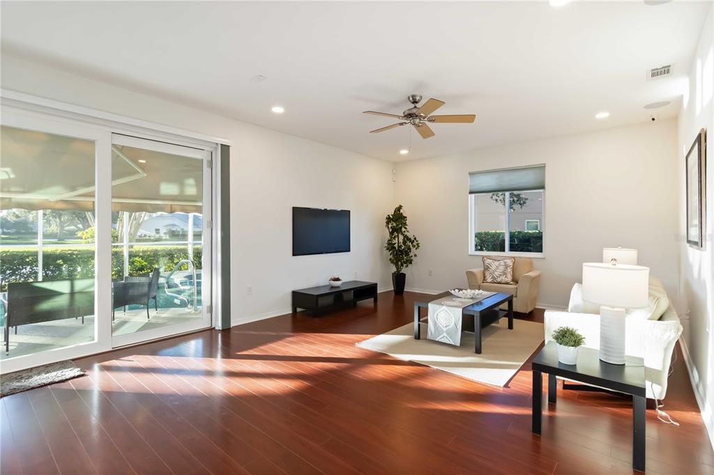 4223 Balmoral Way Sarasota, FL 34238 - Photo 7 of 72 a living room with furniture a flat screen tv and wooden floor