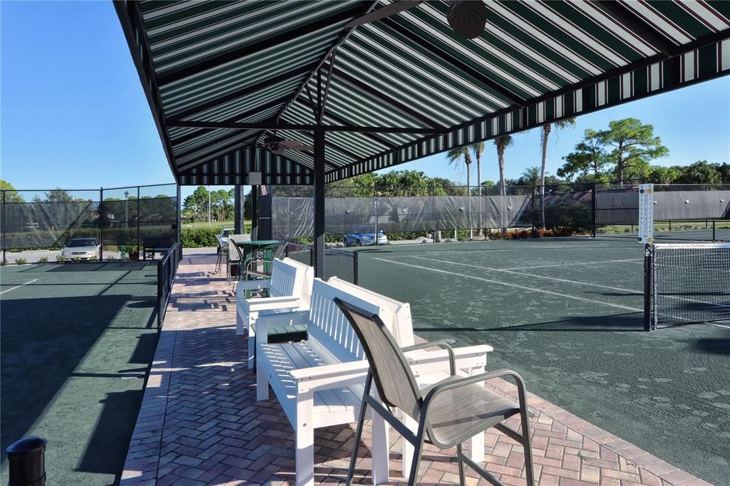 4223 Balmoral Way Sarasota, FL 34238 - Photo 71 of 72 a patio with a table and chairs under an umbrella