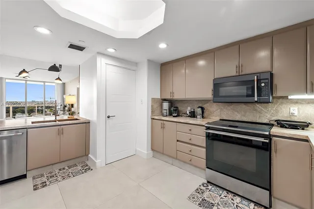 a kitchen with granite countertop cabinets stainless steel appliances and a sink