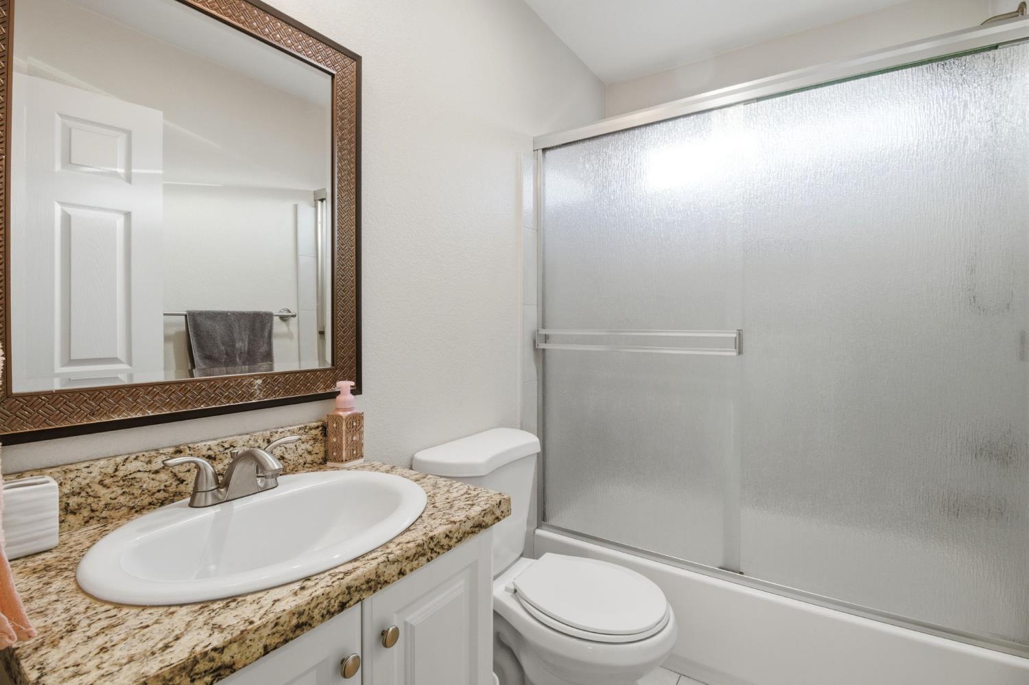 243 Angelus Street Turlock, CA 95380 - Photo 15 of 26 a bathroom with a sink and a mirror
