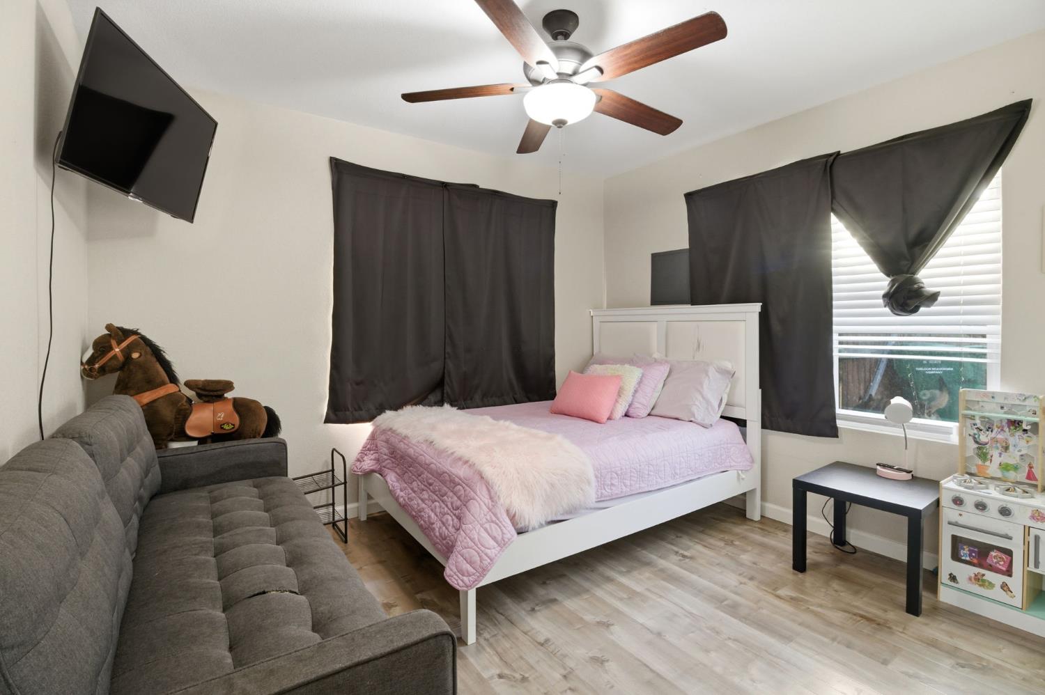 243 Angelus Street Turlock, CA 95380 - Photo 18 of 26 a bedroom with a bed and a flat screen tv