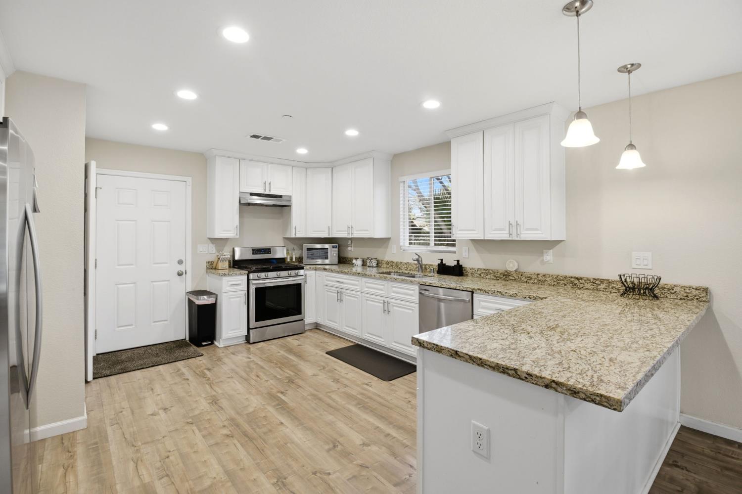 243 Angelus Street Turlock, CA 95380 - Photo 10 of 26 a kitchen with a stove top oven a sink and a refrigerator