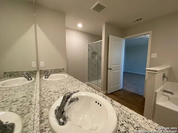 a bathroom with a tub sink and mirror