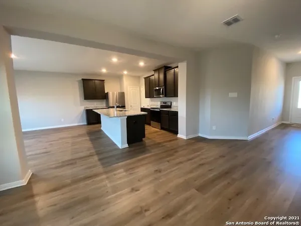a view of kitchen with microwave a stove and wooden floor