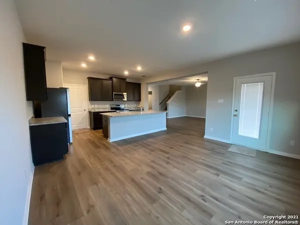 a view of kitchen with kitchen island wooden floor and living room