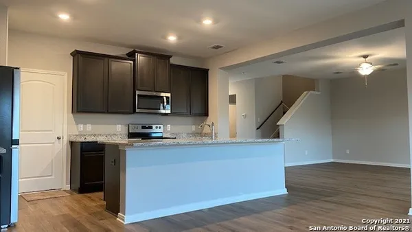 a kitchen with stainless steel appliances granite countertop a sink a stove and a refrigerator