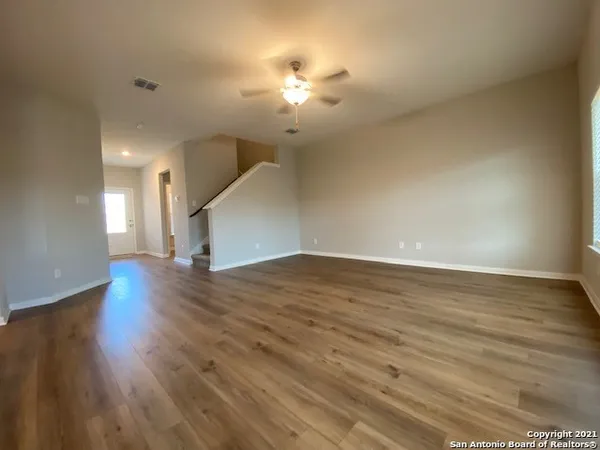 a view of a livingroom with a ceiling fan window and wooden floor