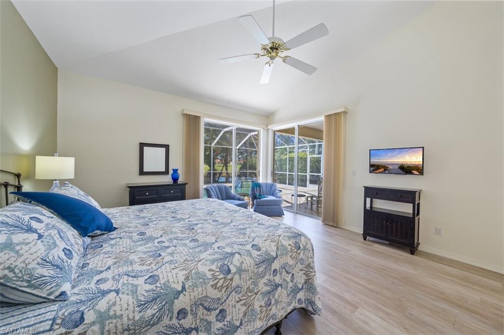 156 Napa Ridge Way Naples, FL 34119 - Photo 14 of 21 a bedroom with a bed and wooden floor