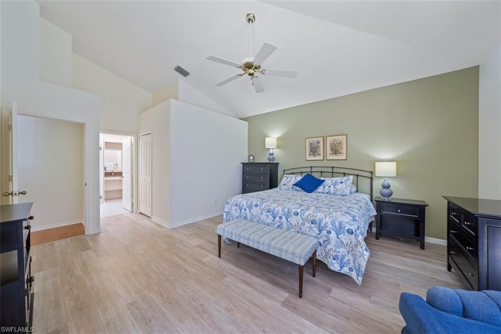 156 Napa Ridge Way Naples, FL 34119 - Photo 15 of 21 a bedroom with a large bed a chandelier and dresser
