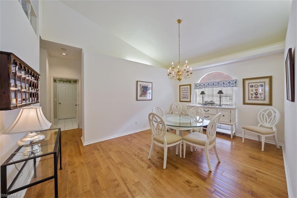 156 Napa Ridge Way Naples, FL 34119 - Photo 9 of 21 a dining room with furniture a chandelier and wooden floor