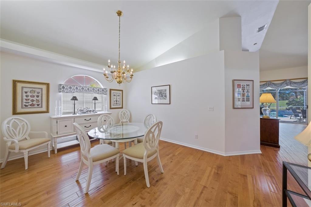 156 Napa Ridge Way Naples, FL 34119 - Photo 10 of 21 a dining room with furniture a chandelier and wooden floor
