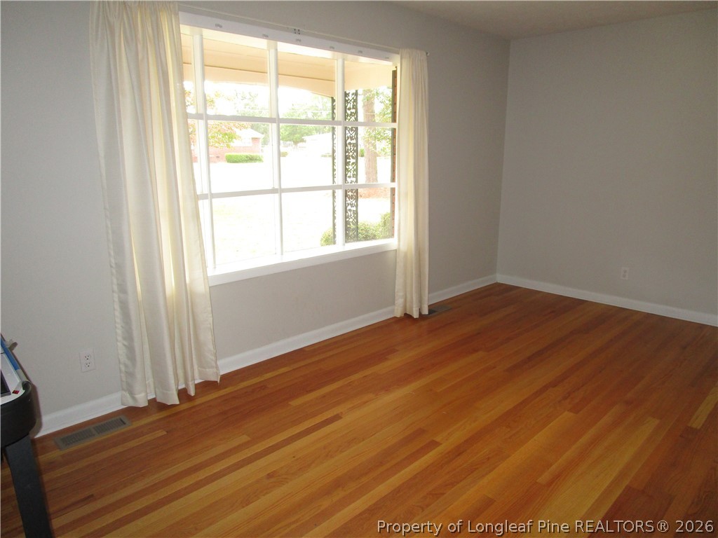 2516 Cumberland Road Fayetteville, NC 28306 - Photo 3 of 20 an empty room with wooden floor and windows
