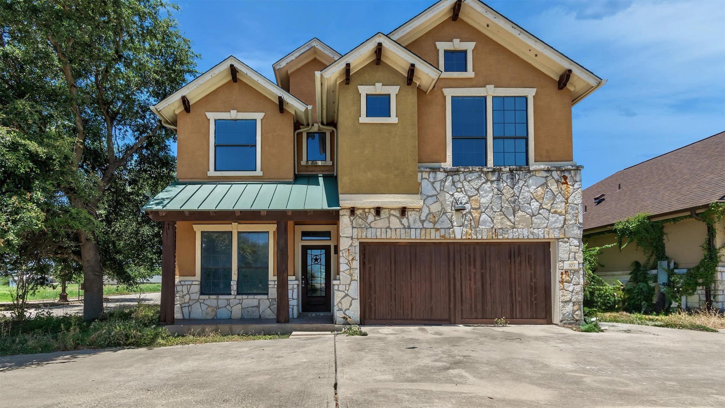 A stone and stucco facade with a green metal awning welcomes you to this distinctive residence.