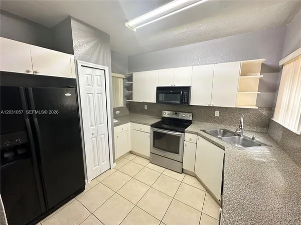 a kitchen with a sink appliances and cabinets