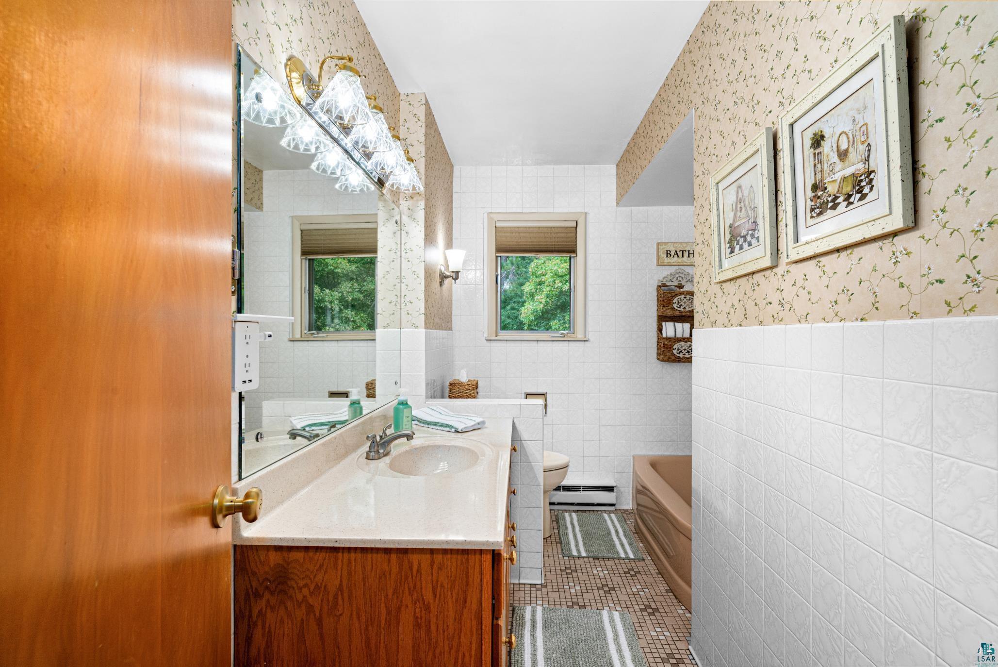 3727 Stebner Road Hermantown, MN 55811 - Photo 18 of 41 Built-in vanity with single sink, wall-mounted mirror, and overhead lighting