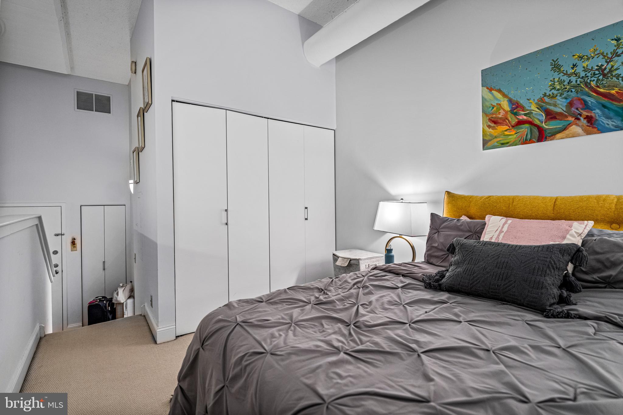 2429-41 Locust Street, Unit 219 Philadelphia, PA 19103 - Photo 18 of 28 a bedroom with a bed and painting on the wall