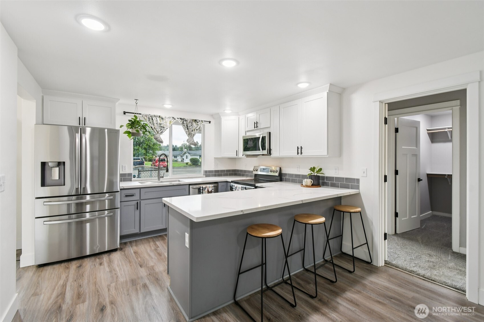 429 Fir Street McCleary, WA 98557 - Photo 9 of 21 a kitchen with stainless steel appliances a sink a stove a refrigerator and island with wooden floor