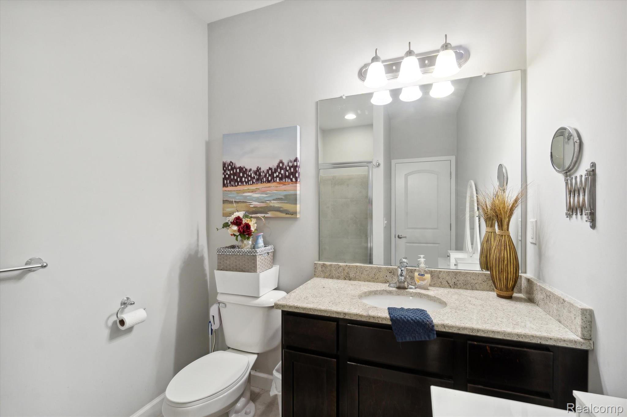5662 Arbor Chase Drive Ann Arbor, MI 48103 - Photo 21 of 27 Bathroom featuring a dark wood-finish vanity with an undermount sink, a light-toned countertop, and a large wall-mounted mirror