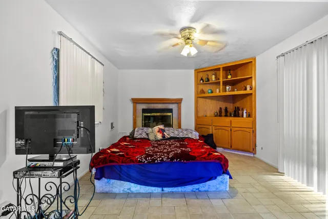 a bedroom with a bed and a flat tv screen on dresser