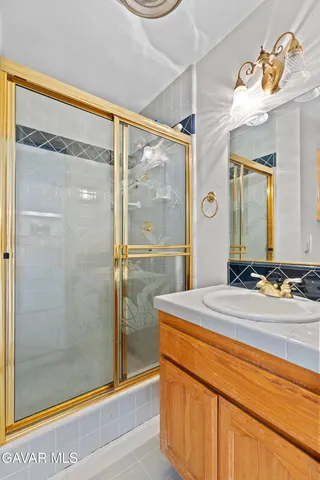 a bathroom with a granite countertop sink mirror and shower