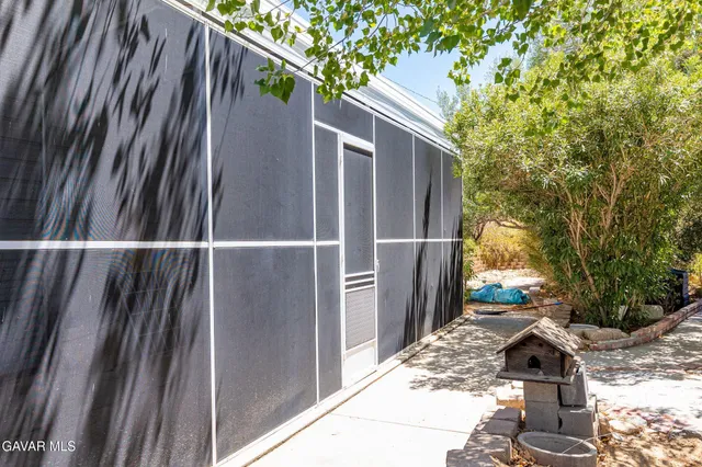 a view of a patio with table and chairs potted plants and large tree