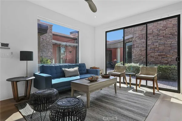 a living room with furniture a rug and a floor to ceiling window