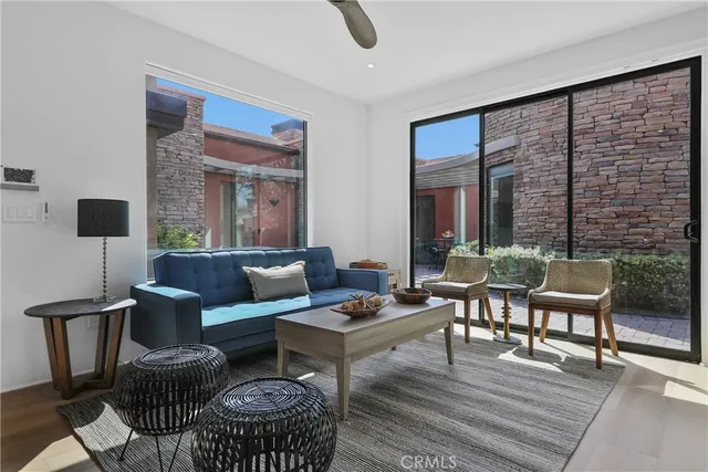 a living room with furniture a rug and a floor to ceiling window