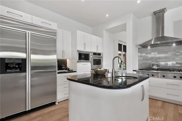 a kitchen with sink a refrigerator and stainless steel appliances