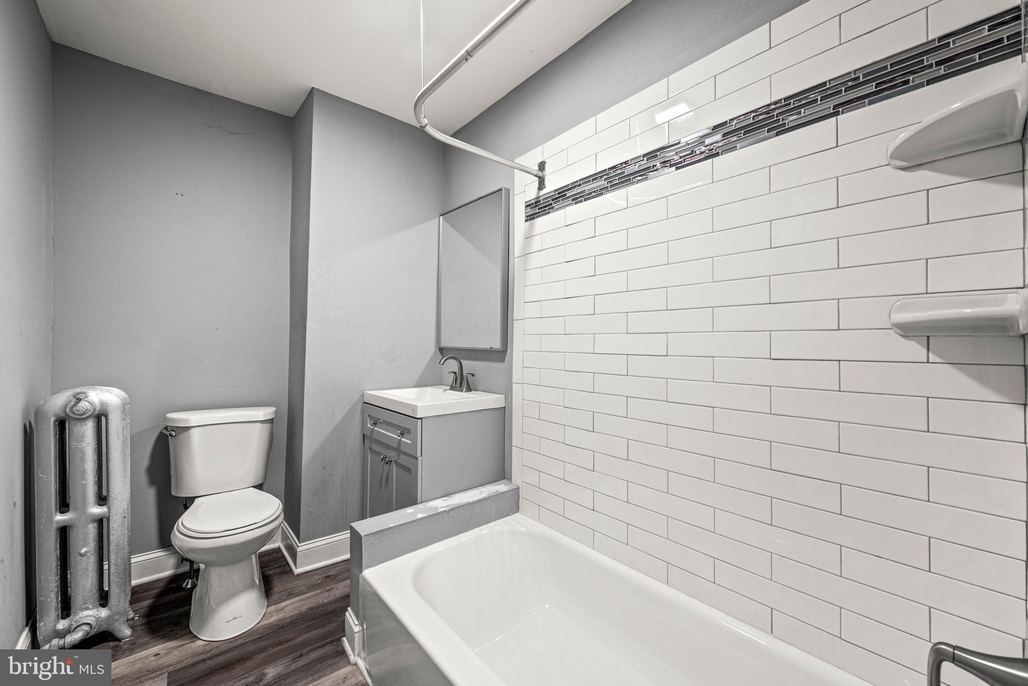 5426 Windsor Street Philadelphia, PA 19143 - Photo 13 of 22 a white toilet sitting next to a white sink and a shower