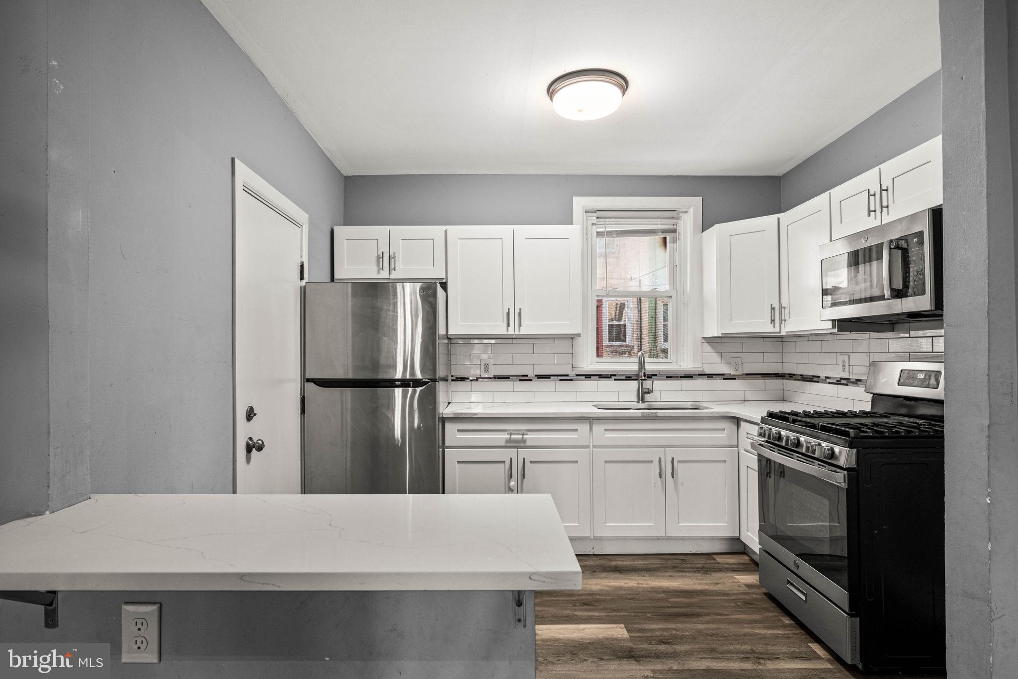 5426 Windsor Street Philadelphia, PA 19143 - Photo 7 of 22 a kitchen with a sink stove and refrigerator