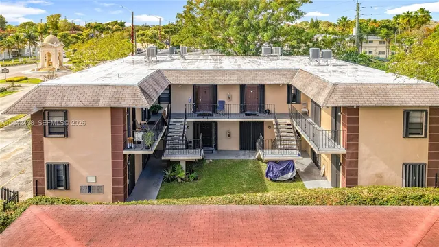 a aerial view of a house with a porch and a table under an umbrella