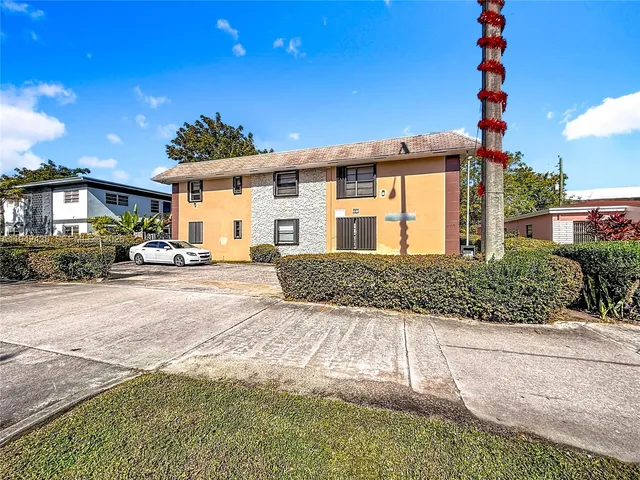 a front view of a house with a yard and car parked