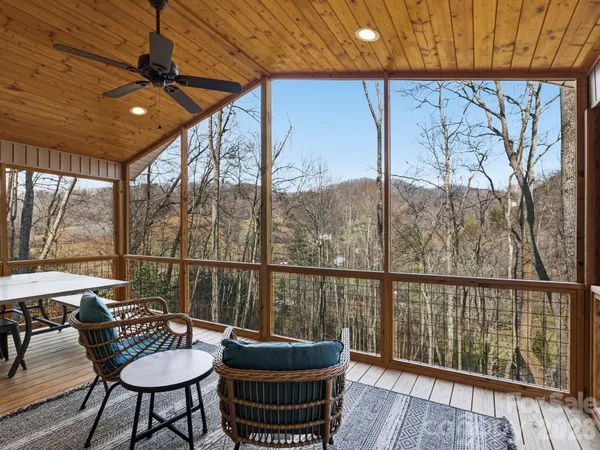 a view of a balcony with chairs and wooden floor