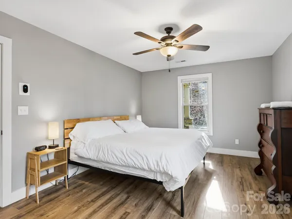 a bedroom with a bed and wooden floor