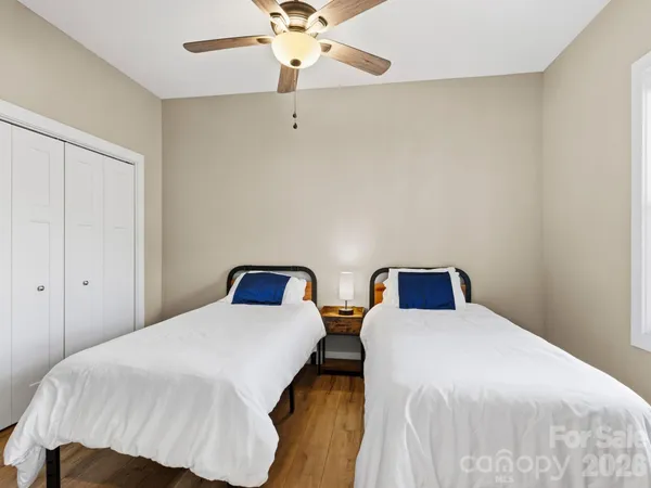 a bedroom with two beds and fan