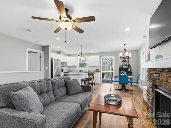 a living room with furniture a fireplace and a chandelier