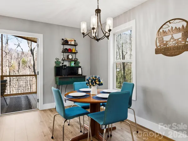 a view of a dining room with furniture a chandelier and wooden floor
