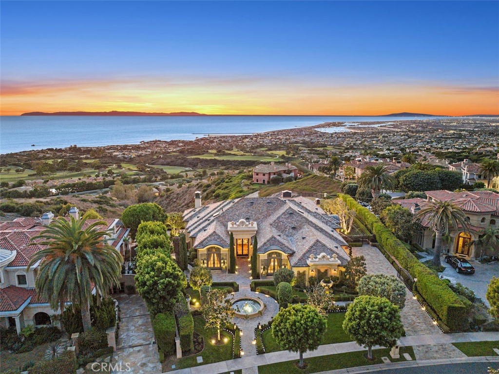 an aerial view of residential houses with outdoor space and ocean view