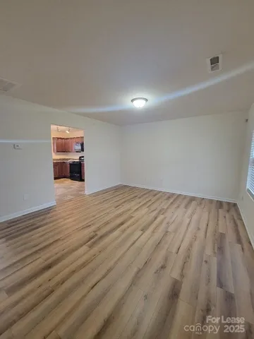 a view of empty room with wooden floor