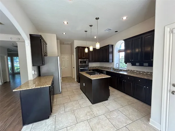 a large kitchen with a large counter top space and stainless steel appliances