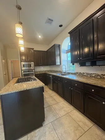 a spacious bathroom with a granite countertop sink a mirror and vanity