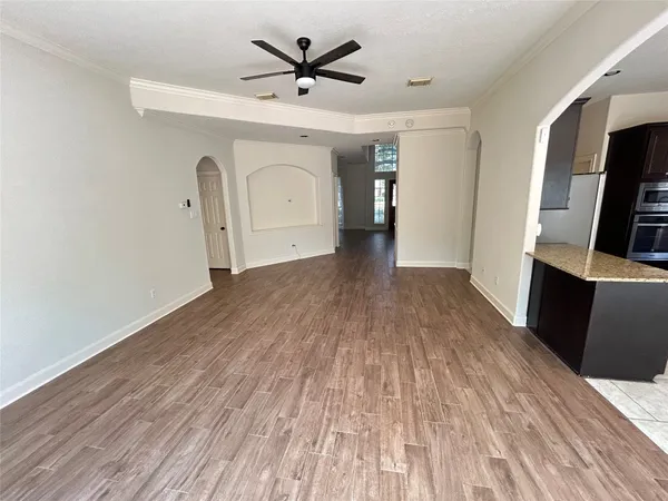 a view of an empty room with a window and wooden floor