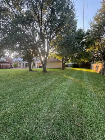 a view of a big yard with large trees