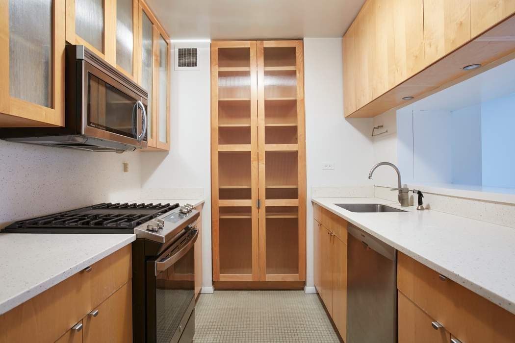 40 East 94th Street, Unit 3D Manhattan, NY 10128 - Photo 3 of 5 a kitchen with stainless steel appliances granite countertop a stove and a microwave